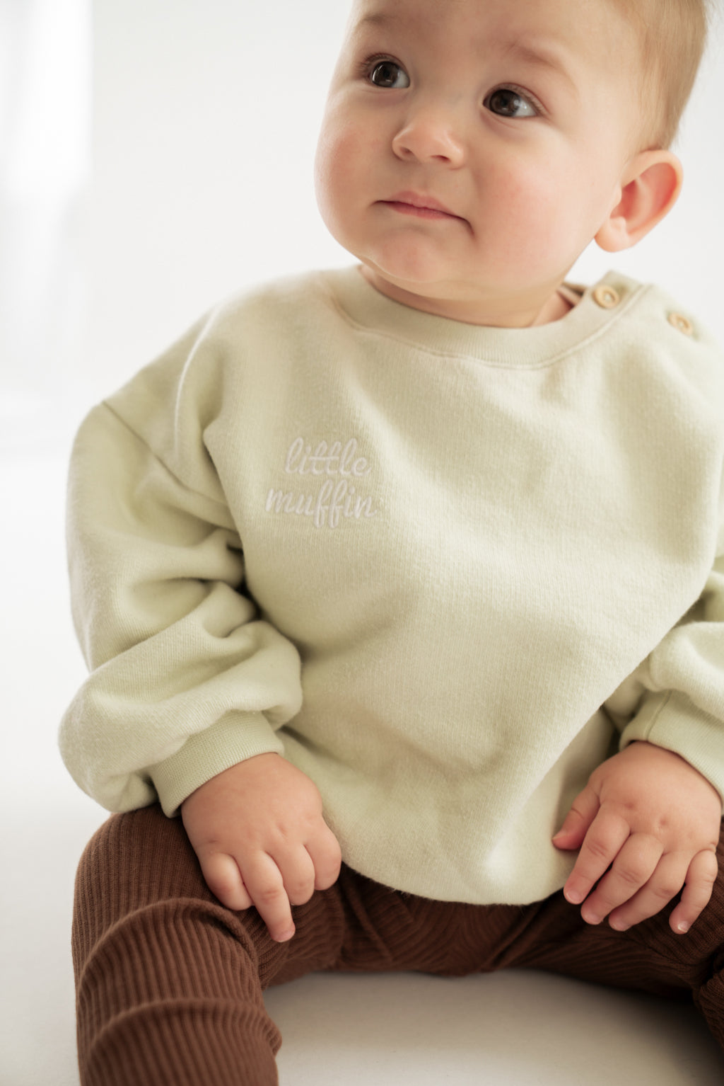 Baby trägt Muffin Pullover aus 100% Bio-Baumwolle